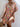 Woman wearing a colorful floral dress against a white wall