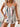 A colorful striped tank top and white shorts with a wooden background
