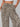 A leopard print pants worn by a woman on a gray background