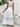 A white dress with lace details in an outdoor setting