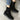 Black suede boots with a buckle on a concrete surface