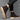 Brown suede Chelsea boots with beige soles worn by a person on a gray background