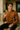 Man in a brown sweater holding a glass of champagne outdoors
