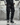 Man walking in city wearing black cargo joggers with sneakers