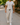 Man wearing light grey cotton wide-leg joggers with black drawstring, walking confidently on a sunny Australian street in casual white tee and sneakers