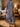 Person in a patterned dress in a room with wooden floors and furniture