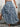 Person wearing a blue floral skirt on a stone pavement