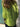 Person wearing a bright green shirt standing against a stone wall