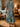 Person wearing a patterned dress in a room with wooden floors and furniture