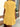 Person wearing a yellow dress standing outdoors near a building