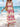 Woman in a beige and pink boho dress standing on a beach with ocean view