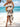 Woman in a white boho dress with black patterns on a beach