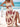 Woman in a white dress with red patterns sitting on a beach