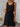 Woman wearing a black sleeveless dress with a white background