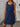 Woman wearing a blue dress indoors with a neutral background