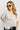 Woman wearing a layered outfit with sunglasses against a white background