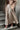 A beige coat and skirt standing on steps