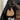 Back view of a woman in a black blazer and white pants wearing a brown woven hobo bag with netted center panel and leather shoulder strap, walking up wooden stairs indoors