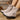 Beige ankle boots with a buckle on a wooden floor