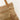 Beige woven bag with tassel on a white background