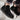 Black Chelsea boots worn with rolled-up jeans on a blurred background