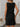 Black sleeveless dress worn by a person indoors with a neutral background