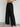 Black wide-leg pants worn by a person on a plain background