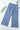 Blue checkered pants on a white background with a leaf and magazine corner