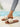 Brown sandals with large cream bows, side view