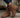 Brown suede boots with zippers on a wooden surface