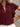 Close-up of a burgundy blouse with ruffled shoulders worn by a person