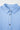 Close-up of a light blue textured shirt with buttons on a white background