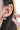 Close-up of a person wearing a silver hoop earring with a clear gemstone