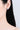 Close-up of an ear wearing a blue gemstone earring on a plain background