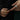 Close-up of hands wearing gold and silver bracelets on a dark background