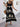 Elegant woman wearing a black boho dress with white patterns