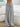 Gray drawstring pants worn by a woman in a minimalistic room with a white couch