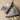 Gray suede Chelsea boots with black soles on a wooden surface