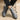 Gray suede shoes worn by a person sitting on a chair with a beige background