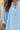 Light blue shirt worn by a person with a necklace, blurred background
