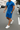 Man wearing a blue outfit with shorts and a t-shirt on a street