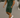 Man wearing a green outfit with white sneakers on a street