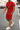 Man wearing a red outfit with white sneakers on a street