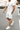 Man wearing a white t-shirt, shorts, and sneakers on a city street