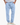 Man wearing light blue textured drawstring pants with relaxed fit and hands in pockets, paired with white sneakers