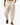 Man wearing loose beige drawstring pants with side pockets and sandals while walking on white background