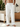 Man wearing relaxed white drawstring lounge pants in a modern living room setting
