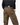 Man wearing taupe cotton cargo pants with multiple pockets and black belt, hands in pockets against a background