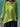 Person wearing a bright green top with a blurred background