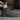 Person wearing a gray suede Chelsea boot on a neutral background